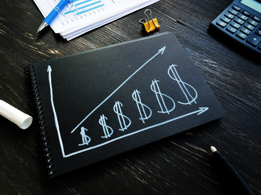 Increase revenue and profit concept. Dollar signs and growing arrow.