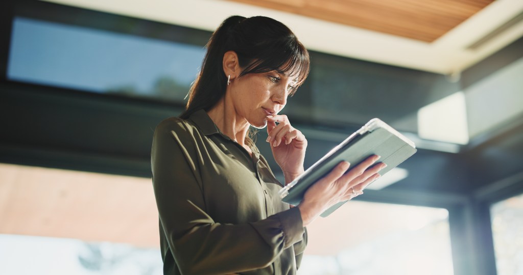 Thinking, business and woman with tablet, below and news agency with planning for column. Mature person, low angle and journalist in office, tech and problem solving with deadline, ideas and solution.